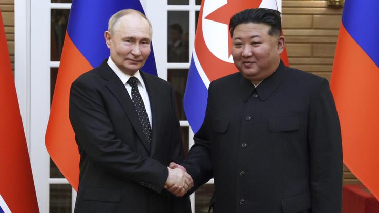 Russian President Vladimir Putin and North Korea's leader Kim Jong Un shake hands.