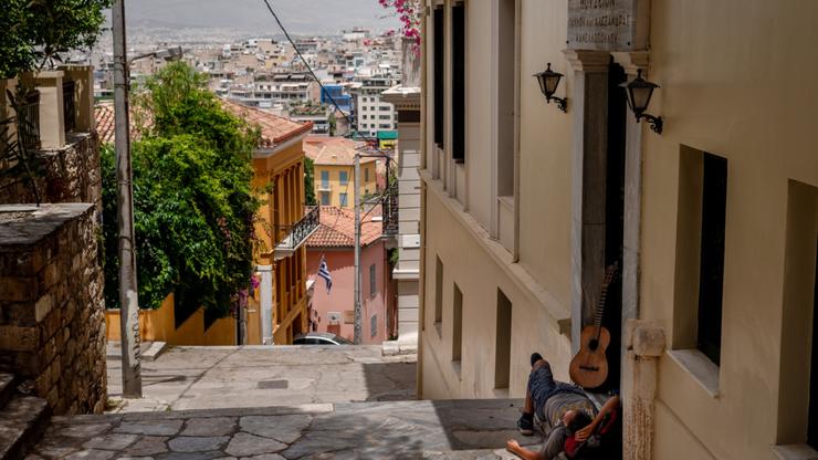 A street busker takes a nap in the shade in Athens, Greece, on Wednesday, June 12, 2024. Authorities in Athens announced the closure of the Acropolis for five hours on Wednesday due to heat wave temperatures that also shut many schools. Photographer: Hilary Swift/Bloomberg via Getty Images